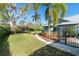 Beautiful backyard featuring palm trees, a small trampoline and lush landscaping at 3951 Palau Dr, Sarasota, FL 34241