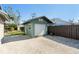 Detached one-car garage with white door, situated on a gravel driveway, adjacent to a fenced-in backyard at 3951 Palau Dr, Sarasota, FL 34241