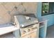 Built-in stainless steel gas grill with granite countertops in an outdoor kitchen area with decorative tile back splash at 3951 Palau Dr, Sarasota, FL 34241