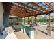 Outdoor kitchen and bar featuring granite countertops under a covered patio overlooking the backyard and pool at 3951 Palau Dr, Sarasota, FL 34241