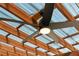 Close up of an outdoor ceiling fan with light fixture on a wood-covered patio, offering both comfort and style at 3951 Palau Dr, Sarasota, FL 34241