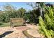 Relaxing backyard garden with a park bench, fish pond and lush tropical landscaping at 3951 Palau Dr, Sarasota, FL 34241