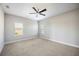 Cozy bedroom with carpet flooring, a ceiling fan, and natural light from two windows at 4744 Benito Ct, Bradenton, FL 34211