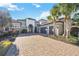 Home's exterior boasts a stone facade and a brick driveway, complemented by tall palm trees at 4744 Benito Ct, Bradenton, FL 34211