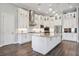 This spacious kitchen is all-white with stainless steel appliances, decorative tile backsplash, and stunning pendant lights at 4744 Benito Ct, Lakewood Ranch, FL 34211