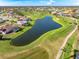 Scenic aerial view of community with lush green golf course and serene lake at 5080 Kilty E Ct, Bradenton, FL 34203