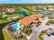 Aerial view of community clubhouse, pool, tennis courts, and golf course at 5080 Kilty E Ct, Bradenton, FL 34203