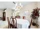 Bright dining room features wood table with white tablecloth and stylish chandelier at 5080 Kilty E Ct, Bradenton, FL 34203