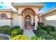 Stunning home entryway with a red-accented archway, white columns, and lovely landscaping at 5080 Kilty E Ct, Bradenton, FL 34203