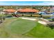 Aerial view of a golf course with a sand trap, a wooden bridge, clubhouse, and a scenic lakeside restaurant at 5080 Kilty E Ct, Bradenton, FL 34203