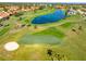 Aerial view of a picturesque golf course features a serene pond and manicured green at 5080 Kilty E Ct, Bradenton, FL 34203