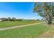 Scenic view of a lush green golf course with a tranquil pond and beautiful homes in the background at 5080 Kilty E Ct, Bradenton, FL 34203