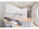 Well-lit kitchen with white cabinetry, tile backsplash, and breakfast bar seating at 5080 Kilty E Ct, Bradenton, FL 34203