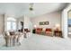 Light-filled living room featuring a ceiling fan, carpeted floors, and a view of the front doors at 5080 Kilty E Ct, Bradenton, FL 34203