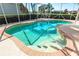 Refreshing pool with a spa and safety handrail, surrounded by a brick trim and beautiful landscaping at 5080 Kilty E Ct, Bradenton, FL 34203