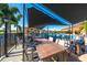 Outdoor poolside seating offers a relaxing dining experience with shaded tables and views of the lush surroundings at 5080 Kilty E Ct, Bradenton, FL 34203