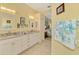 Bright bathroom features tiled floors, double sink vanity with white cabinetry, and doorway to bedroom at 538 Fallbrook Dr, Venice, FL 34292