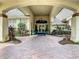 Inviting entrance featuring a covered walkway, manicured landscaping, and a brick paver driveway at 538 Fallbrook Dr, Venice, FL 34292