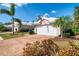 Well maintained home exterior featuring a two car garage, brick driveway and mature landscaping at 538 Fallbrook Dr, Venice, FL 34292