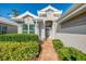 Charming front entry with brick walkway, lush landscaping, and a cozy seating area at 538 Fallbrook Dr, Venice, FL 34292