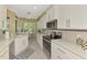 Modern kitchen featuring white cabinetry, stainless steel appliances, and an adjacent breakfast nook at 538 Fallbrook Dr, Venice, FL 34292