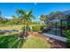 A screened-in patio with colorful Adirondack chairs overlooks the manicured golf course at 538 Fallbrook Dr, Venice, FL 34292