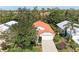 Aerial of home showcasing mature trees, red tile roof, manicured yard, and attached two-car garage at 5513 83Rd E Ter, Sarasota, FL 34243