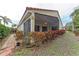 Back of house with screened in patio and lush foliage at 5513 83Rd E Ter, Sarasota, FL 34243