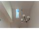 Modern chandelier hanging from a sloped ceiling with a window at 5618 Monte Rosso Rd, Sarasota, FL 34243