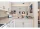 Kitchen featuring white appliances, white cabinets and stone look countertops with an adjoining dining area at 5618 Monte Rosso Rd, Sarasota, FL 34243