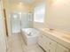 Bright bathroom featuring a soaking tub, a tiled shower and double vanity at 5638 Oakshire Ave, Sarasota, FL 34233