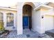 Inviting front entrance with a blue double door, arched entryway, and manicured landscaping, creating a welcoming curb appeal at 5638 Oakshire Ave, Sarasota, FL 34233