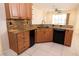 Kitchen with granite countertops, wood cabinets, stainless steel sink, and black appliances at 5638 Oakshire Ave, Sarasota, FL 34233