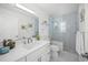 Bright bathroom featuring a white vanity with double sinks, a glass enclosed shower and a water closet at 615 Avenida Del Norte, Sarasota, FL 34242