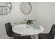 Cozy dining area featuring a round table, modern chairs, and stylish decorative mirrors on the shiplap wall at 615 Avenida Del Norte, Sarasota, FL 34242