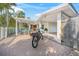 Exterior view of a home showing a brick driveway, wooden privacy fence, a pergola and a bike parked by the entrance at 615 Avenida Del Norte, Sarasota, FL 34242