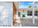 Close-up of home exterior showcasing white siding, wood accents, and a covered patio with stylish outdoor lighting at 615 Avenida Del Norte, Sarasota, FL 34242