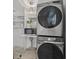 Modern laundry room with stacked washer and dryer and ample shelving for storage at 615 Avenida Del Norte, Sarasota, FL 34242