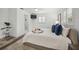 Bright main bedroom featuring plank floors, white walls, tray ceiling, and bath access at 615 Avenida Del Norte, Sarasota, FL 34242