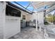 Outdoor kitchen and dining area with seating, television, grill, and bar, all under an open-air structure at 615 Avenida Del Norte, Sarasota, FL 34242