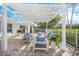 Inviting patio with comfortable seating under a pergola, perfect for outdoor relaxation and entertaining, with tropical landscaping at 615 Avenida Del Norte, Sarasota, FL 34242