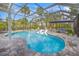 Beautiful screened-in pool area featuring a pool, spa, and lounge seating with lush tropical landscaping at 615 Avenida Del Norte, Sarasota, FL 34242