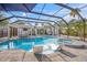 Screened-in pool and patio with integrated spa, sun shelves, outdoor seating and kitchen with bar seating at 615 Avenida Del Norte, Sarasota, FL 34242