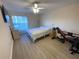 Bedroom with a bed, ceiling fan, large window, and exercise equipment at 6330 7Th W Ave, Bradenton, FL 34209