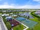 Aerial view of community amenities featuring a pool, playground, tennis, and basketball courts by a pond at 6708 162Nd E Pl, Parrish, FL 34219