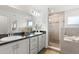 Bathroom featuring dual sinks, a spacious countertop, a glass-enclosed shower, and a separate bathtub at 6708 162Nd E Pl, Parrish, FL 34219