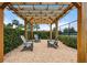 Outdoor pergola with three chairs and pea gravel surrounded by a high hedge at 6708 162Nd E Pl, Parrish, FL 34219