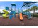 Modern playground with multiple slides and climbing structures on a red rubber surface at 6708 162Nd E Pl, Parrish, FL 34219