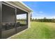 View of the screened patio with stylish outdoor furniture, overlooking the well-maintained backyard at 6708 162Nd E Pl, Parrish, FL 34219