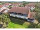 Aerial view of a condo featuring a screen enclosed balcony and porch, plus red tiled roofs and greenery at 7232 Cedar Hollow Cir # 7232, Bradenton, FL 34203